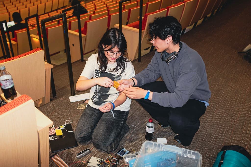 Team members assembling and soldering the Canary prototype electronics during the hackathon