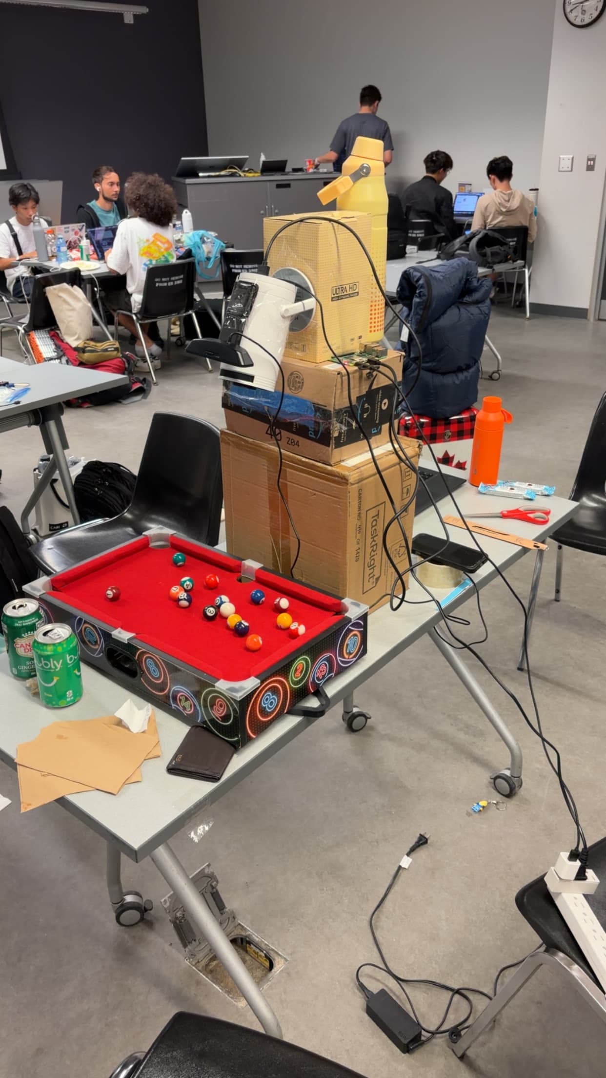 The Otli camera and projector rig assembled on cardboard boxes next to the mini pool table at Hack the North